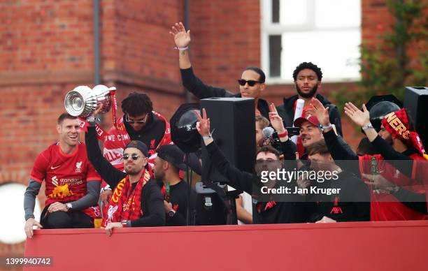 Jordan Henderson of Liverpool lifts The FA Cup Trophy in celebration with teammates during the Liverpool Trophy Parade on May 29, 2022 in Liverpool,...