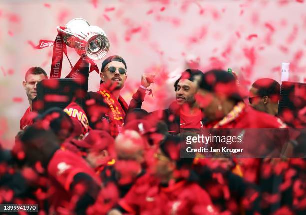 Jordan Henderson of Liverpool lifts The FA Cup Trophy in celebration with teammates during the Liverpool Trophy Parade on May 29, 2022 in Liverpool,...