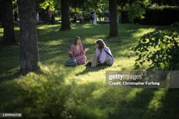 People relax in the Spring sunshine in a park as the city hosts events to celebrate Kyiv Day on the last weekend of May on May 29, 2022 in Kyiv,...