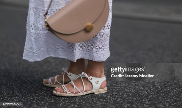 Aline Kaplan is seen wearing a French Connection white dress, Agneel beige bag and Chanel white sandals on May 25, 2022 in Berlin, Germany.