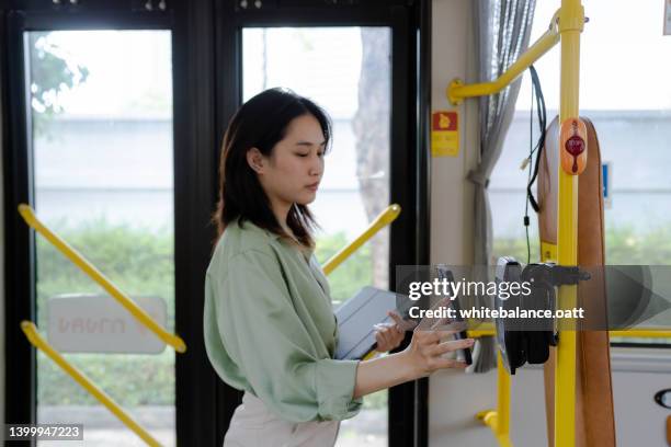 freelancer asian woman using travel card to pay for public bus ride - tap card stock pictures, royalty-free photos & images