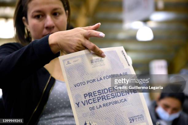 Colombian citizen holds the electoral card to cast her vote during the presidential election day on May 29, 2022 in Bogota, Colombia.