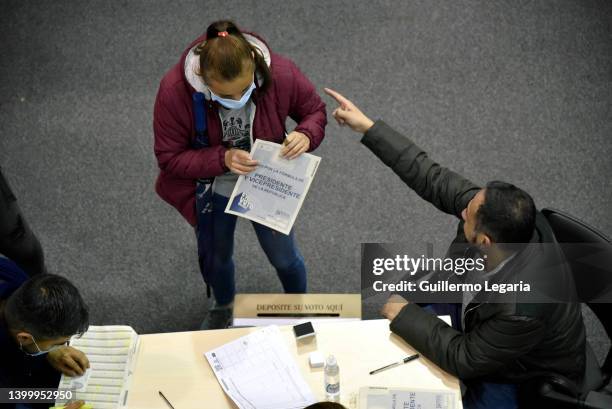 Colombian citizen receives the electoral card to cast her vote during the presidential election day on May 29, 2022 in Bogota, Colombia.