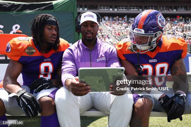 Running Backs coach Will Johnson of the Pittsburgh Maulers reviews a play with Madre London and Mikey Daniel in the second quarter of the game...