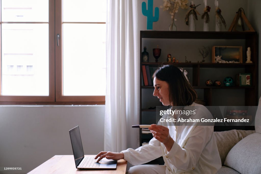 Woman looking at the computer for pregnancy test instructions.