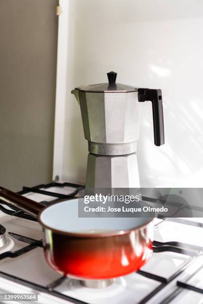 vintage metal coffee maker and pot placed on burning gas cooker in bright kitchen at home. making fresh coffee in old moka pot. - big country breakfast stock-fotos und bilder