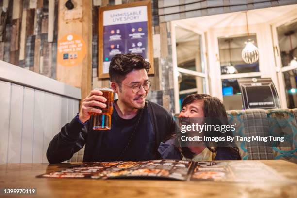 dad & daughter looking at food menu together in restaurant joyfully - kids menu photos et images de collection