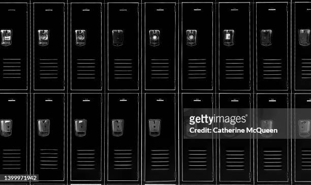 american epidemic of gun violence, debate over school safety initiatives & second amendment protections: row of 18 black traditional metal school lockers - violence prevention stock pictures, royalty-free photos & images