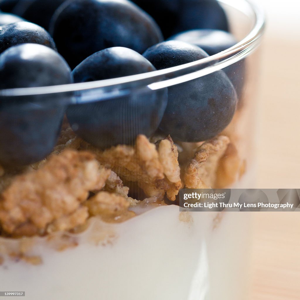 Yogurt, corn flakes and blueberries in glass