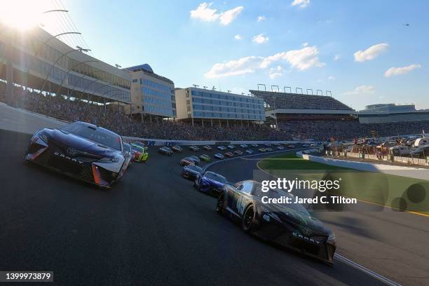 Denny Hamlin, driver of the FedEx Ground Toyota, and Kurt Busch, driver of the Monster Energy Toyota, lead the field prior to the green flag of the...