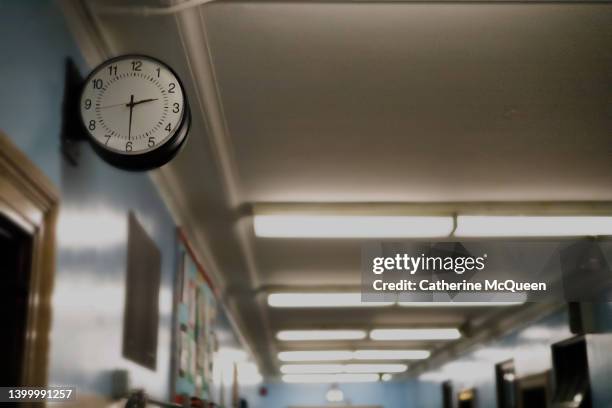 partial darkened view of school corridor with defocused exit sign in the background - shooting crime foto e immagini stock