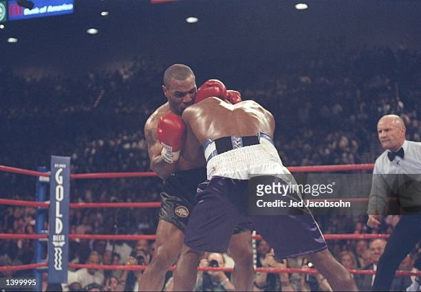 Evander Holyfield and Mike Tyson lock heads during their heavyweight title fight at the MGM Grand Garden in Las Vegas, Nevada. Holyfield won the...