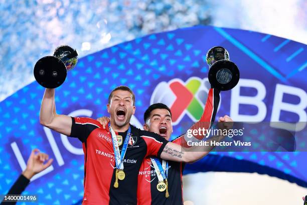 Martin Nervo and Aldo Rocha of Atlas lift the Campeon de Campeones and Liga MX champion's trophies after winning the final second leg match between...