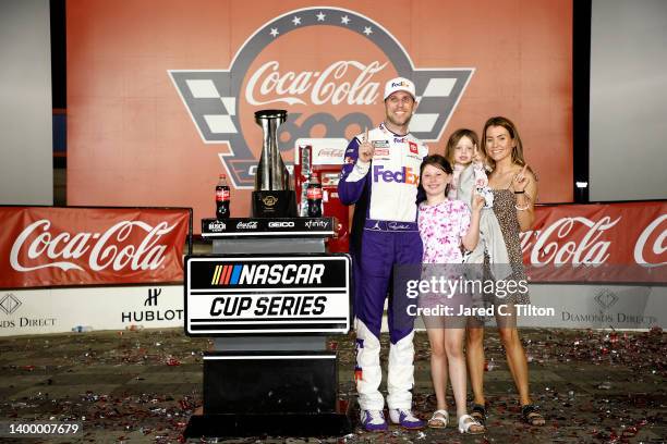 Denny Hamlin, driver of the FedEx Ground Toyota, celebrates with Jordan Fish and Taylor and Molly, in Victory Lane after winning the NASCAR Cup...