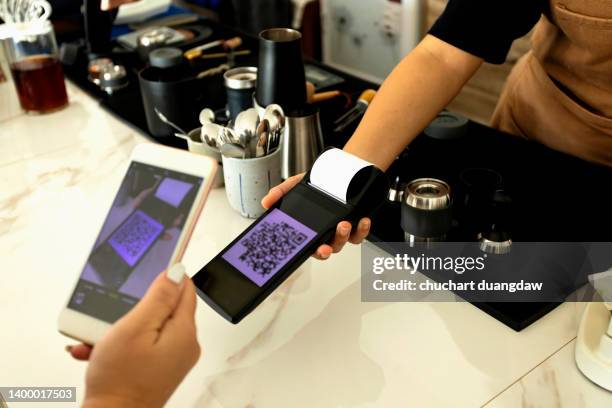 woman scanning qr code with making a quick and easy contactless payment with her smartphone in a cafe - qr code food and drink stock pictures, royalty-free photos & images