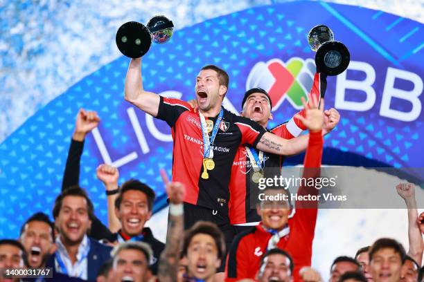 Martin Nervo and Aldo Rocha of Atlas lift the Campeon de Campeones and Liga MX champion's trophies after winning the final second leg match between...