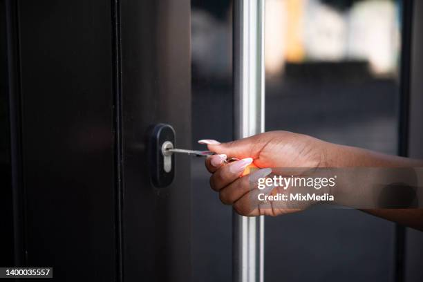 unrecognizable woman unlocking the door - unlocking stock pictures, royalty-free photos & images