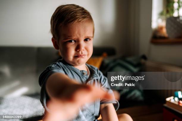 cute little crying toddler reaching for camera - tantrum stock pictures, royalty-free photos & images