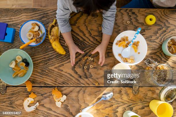making a face with cereal - messy table stock pictures, royalty-free photos & images