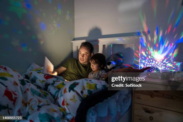 padre che legge la favola della buonanotte - libro illustrato foto e immagini stock