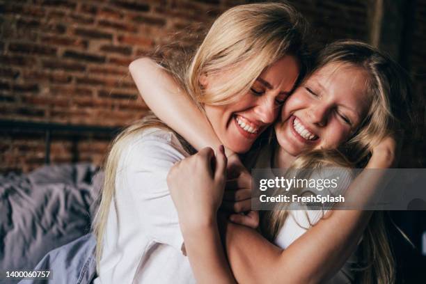 mother and daughter hugging each other - 14 year old blonde girl stock pictures, royalty-free photos & images