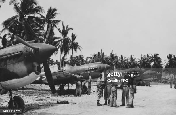 Ground crew prepare Curtiss P-40 Kittyhawk fighter and ground-attack aircraft of No 76 Squadron RAAF on the coral surfaced Momote airfield captured...