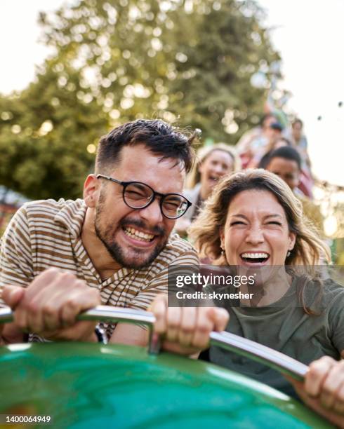 fröhliches paar auf achterbahn im vergnügungspark. - achterbahn stock-fotos und bilder