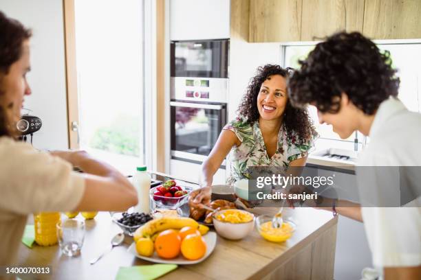 mother and sons eating breakfast together - mother's day breakfast stock pictures, royalty-free photos & images