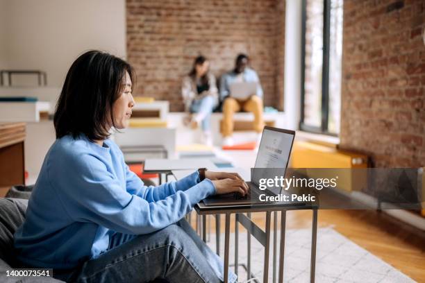 young casually clothed woman shopping online for clothes in office cafeteria - student fashion stock pictures, royalty-free photos & images