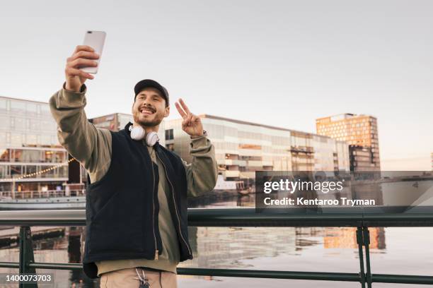 a man taking a selfie in i city landscape - mane stock pictures, royalty-free photos & images