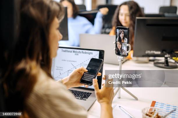 joven empresaria en una reunión en línea en la oficina - nueva-normalidad-concepto fotografías e imágenes de stock