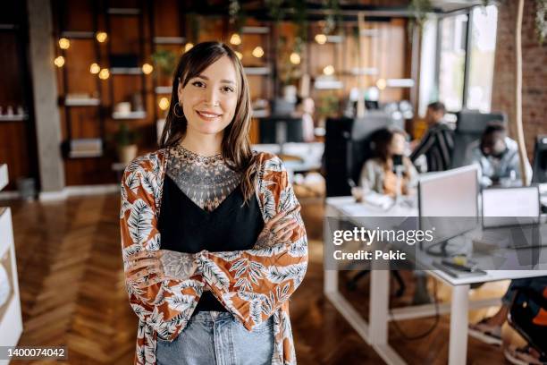 young beautiful smiling tattooed woman posing in the office - founder stock pictures, royalty-free photos & images