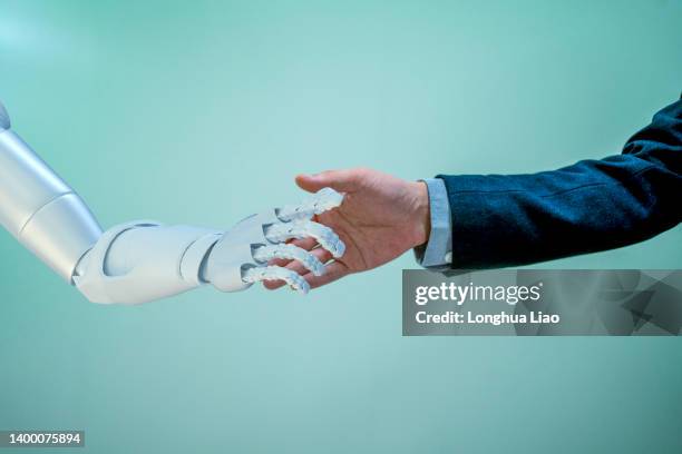 a robotic arm touches a person's arm - robot hand human hand stock pictures, royalty-free photos & images