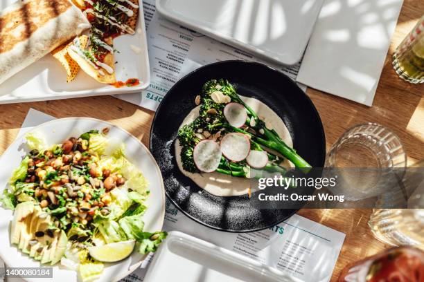 a variety of organic vegan food freshly served on the table at outdoor restaurant - salat im glas stock-fotos und bilder