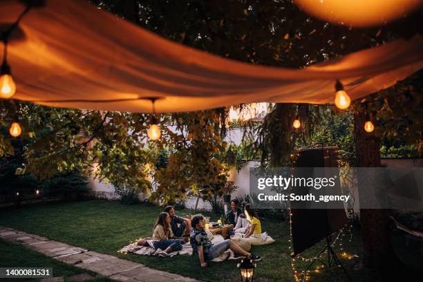 friends watching movie on the video projector in the backyard garden - garden lighting bildbanksfoton och bilder