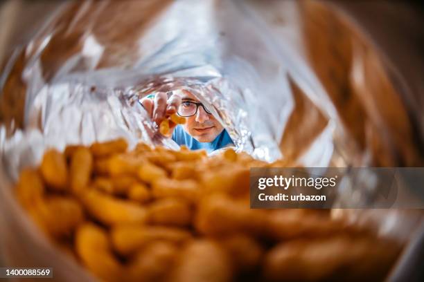 young man eating flips from the bag's pov - fish eye lens stock pictures, royalty-free photos & images