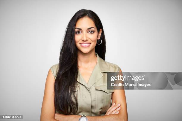 smiling beautiful female ceo with arms crossed - capelli neri foto e immagini stock