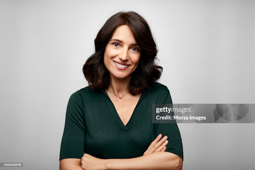 Smiling brunette businesswoman with arms crossed