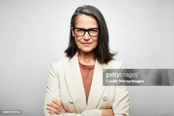 mature female professional with arms crossed - grey blazer stock pictures, royalty-free photos & images