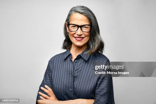 mature female ceo with arms crossed - striped blouse stock pictures, royalty-free photos & images