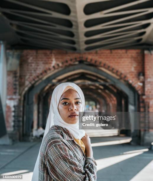 portrait d’une jeune femme portant le hijab sur oberbaumbrücke à berlin - voile religieux photos et images de collection