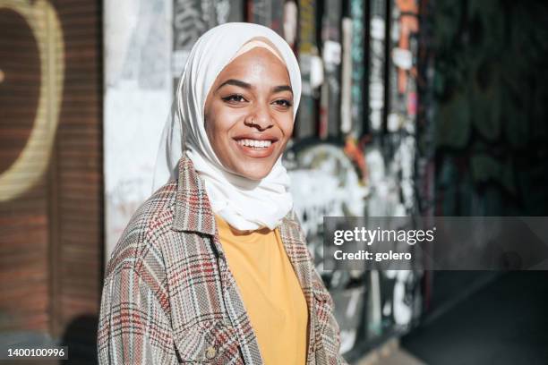 portrait of smiling young woman with hijab in berlin - berlin graffiti stock pictures, royalty-free photos & images