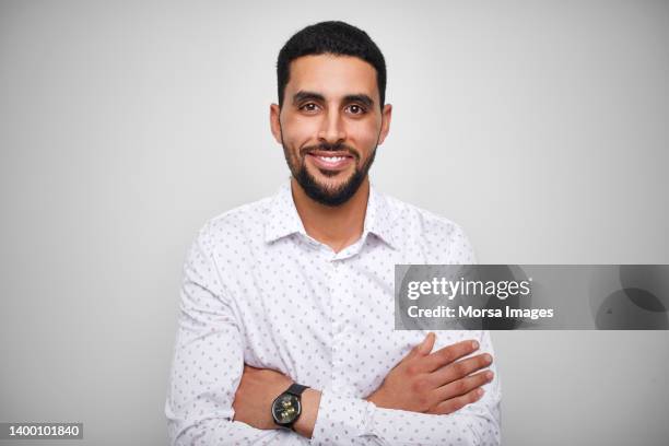smiling male design professional with arms crossed - nordafrikanischer abstammung stock-fotos und bilder
