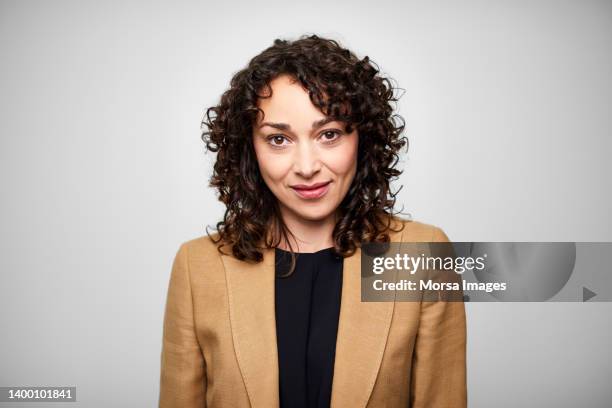 confident businesswoman with curly brown hair - brown blazer stock pictures, royalty-free photos & images