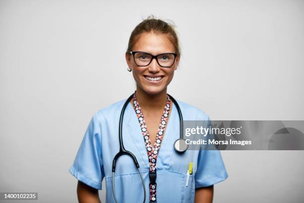 smiling female nurse against white background - nurse uniform stock pictures, royalty-free photos & images