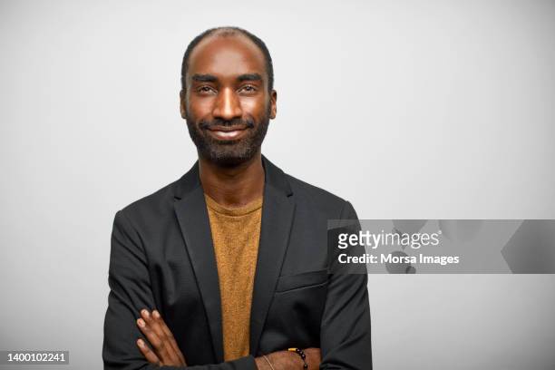african smiling male design professional with arms crossed - creative director stock pictures, royalty-free photos & images