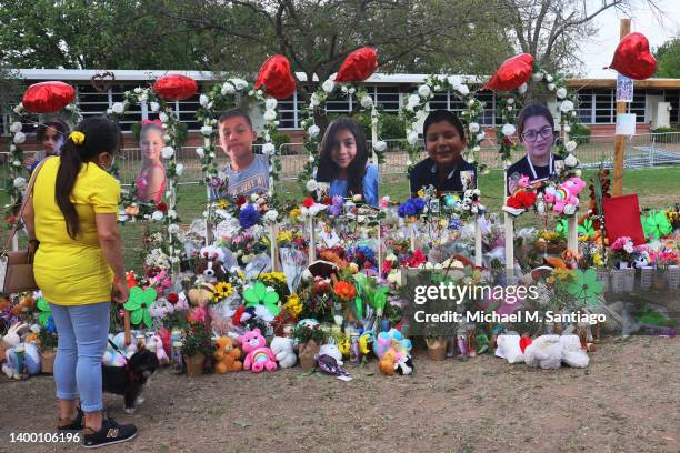 Woman looks down at a memorial for the 19 children and two adults killed on May 24th during a mass shooting at Robb Elementary School on May 30, 2022...