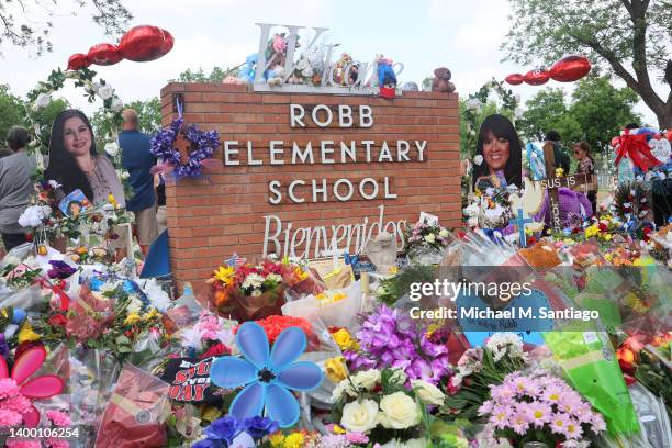 People visit a memorial for the 19 children and two adults killed on May 24th during a mass shooting at Robb Elementary School on May 30, 2022 in...