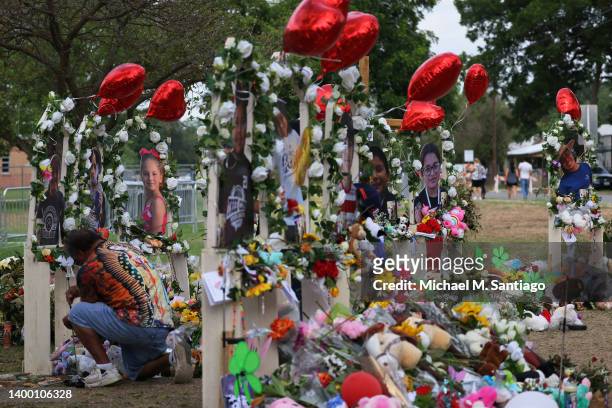Man places a candle on a memorial for the 19 children and two adults killed on May 24th during a mass shooting at Robb Elementary School on May 30,...