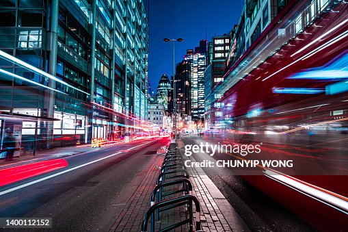 Rote Londoner Busse rasen durch die Nachtstraße der City-Wolkenkratzer Rote Londoner Busse rasen durch die Nachtstraße der City-Wolkenkratzer